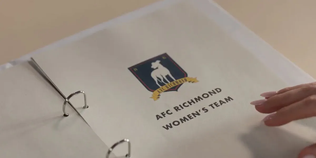 A page in a binder with the AFC Richmond logo printed on it, and beneath it the words "AFC Richmond Women's Team"