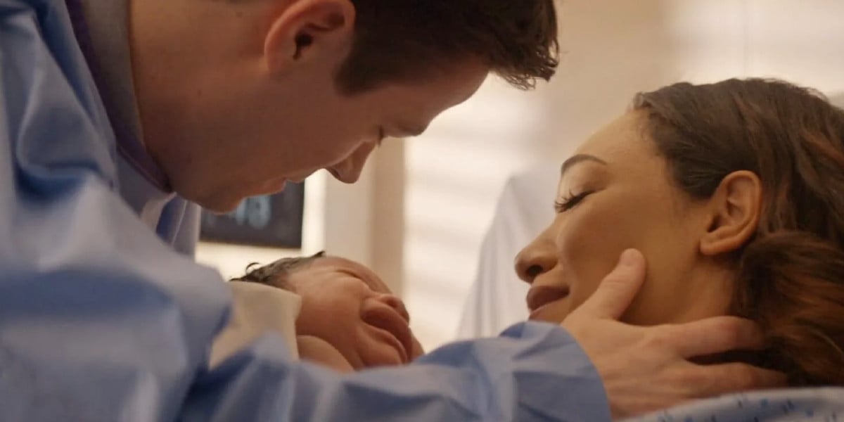 Grant Gustin as Barry Allen, Candice Patton as Iris West-Allen holding baby Nora in The Flash series finale 