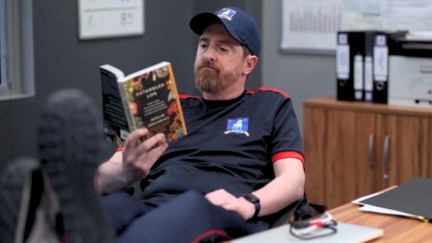 Coach Beard reads a book called Entangled Life at his desk in Ted Lasso.