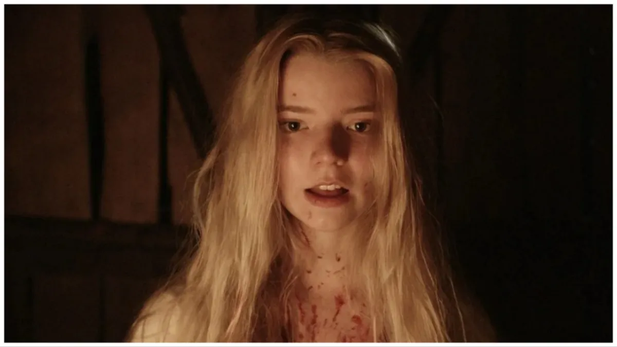 anya taylor joy in the witch, staring at something with her hair loose around her shoulders.