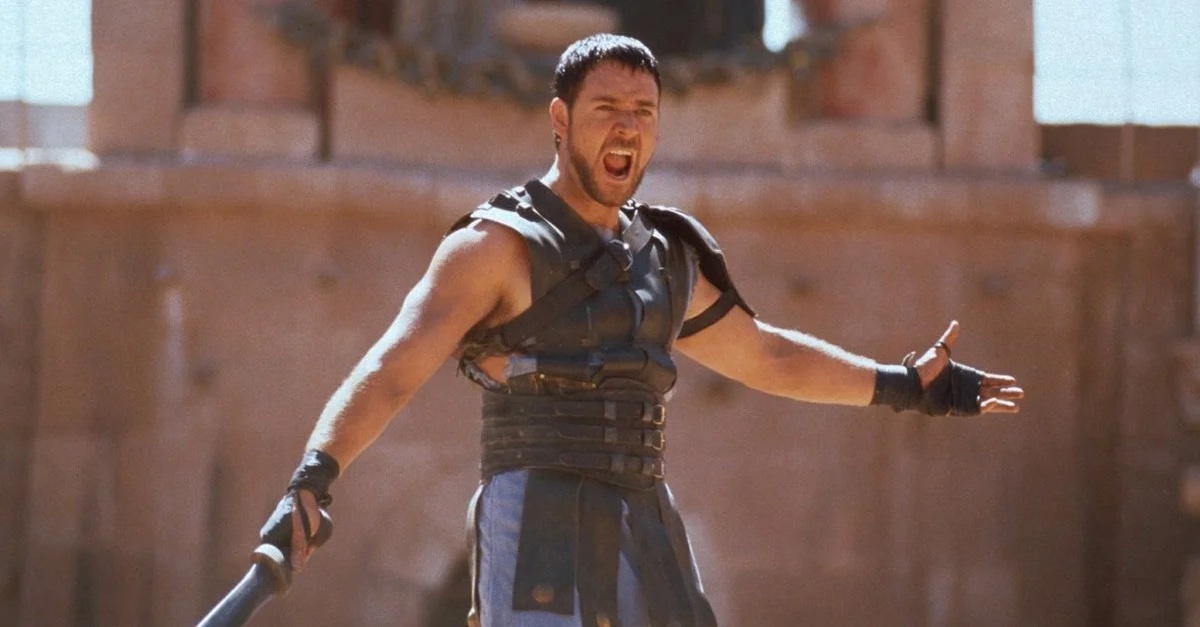 A white man in gladiator armor stands yelling with a weapon in his hand in "Gladiator"