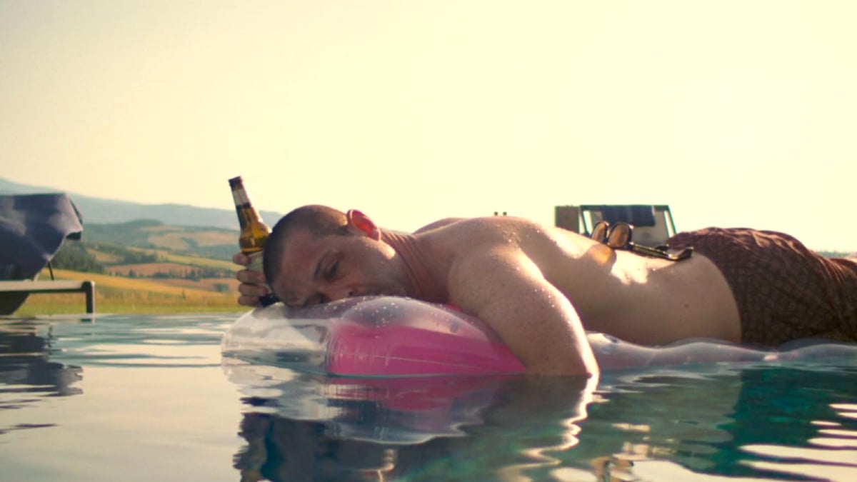 Kendall Roy (Jeremy Strong) lays on a pool float, looking despondent with a beer in his hand in 'Succession' season 3