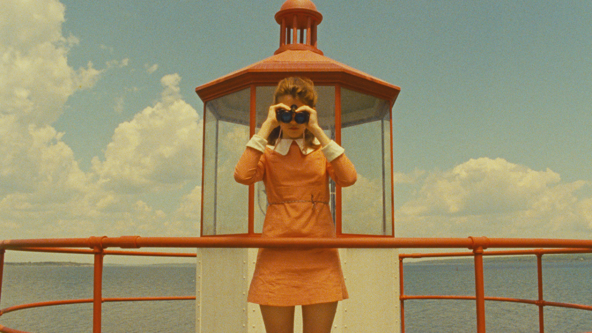 Suzy (Kara Hayward) stands in front of a lighthouse, gazing out of binoculars in Wes Anderson's 'Moonrise Kingdom'