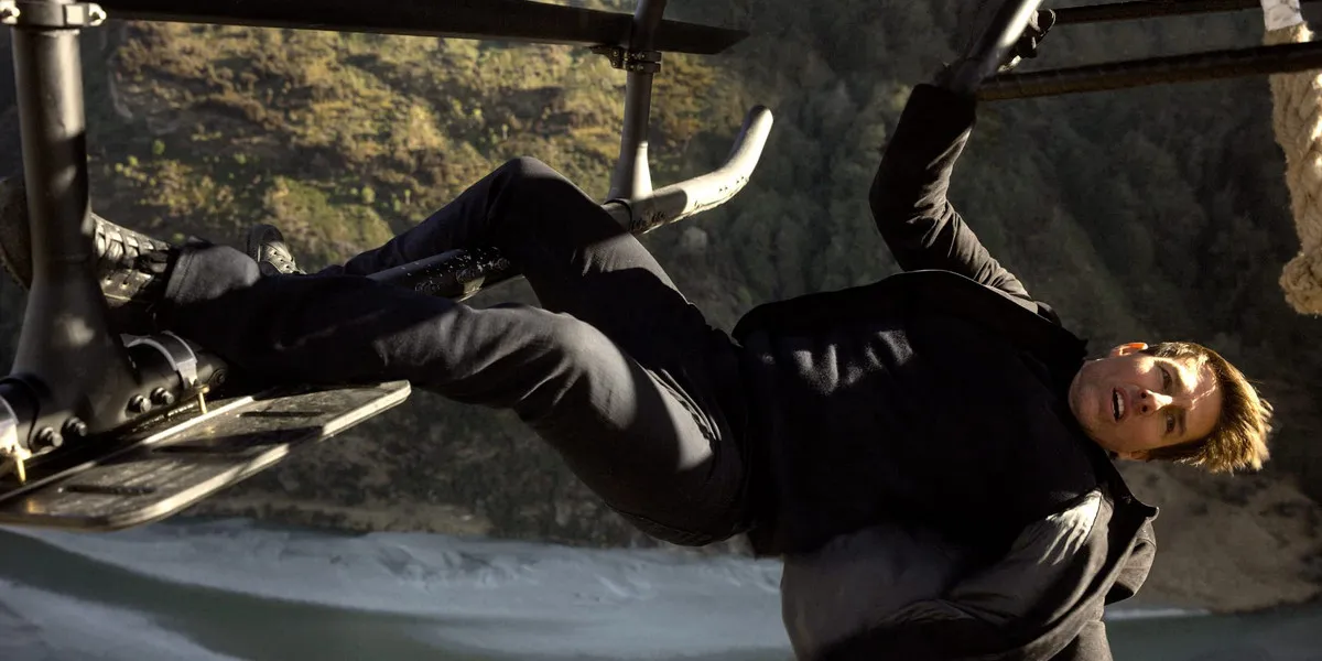 Tom Cruise as Ethan Hunt hanging from a helicopter in Mission: Impossible - Fallout 