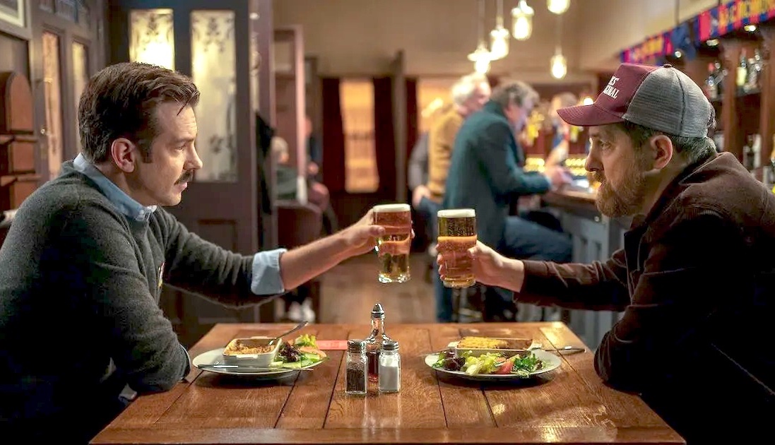 Ted and Beard clink glasses on Apple TV+'s Ted Lasso.