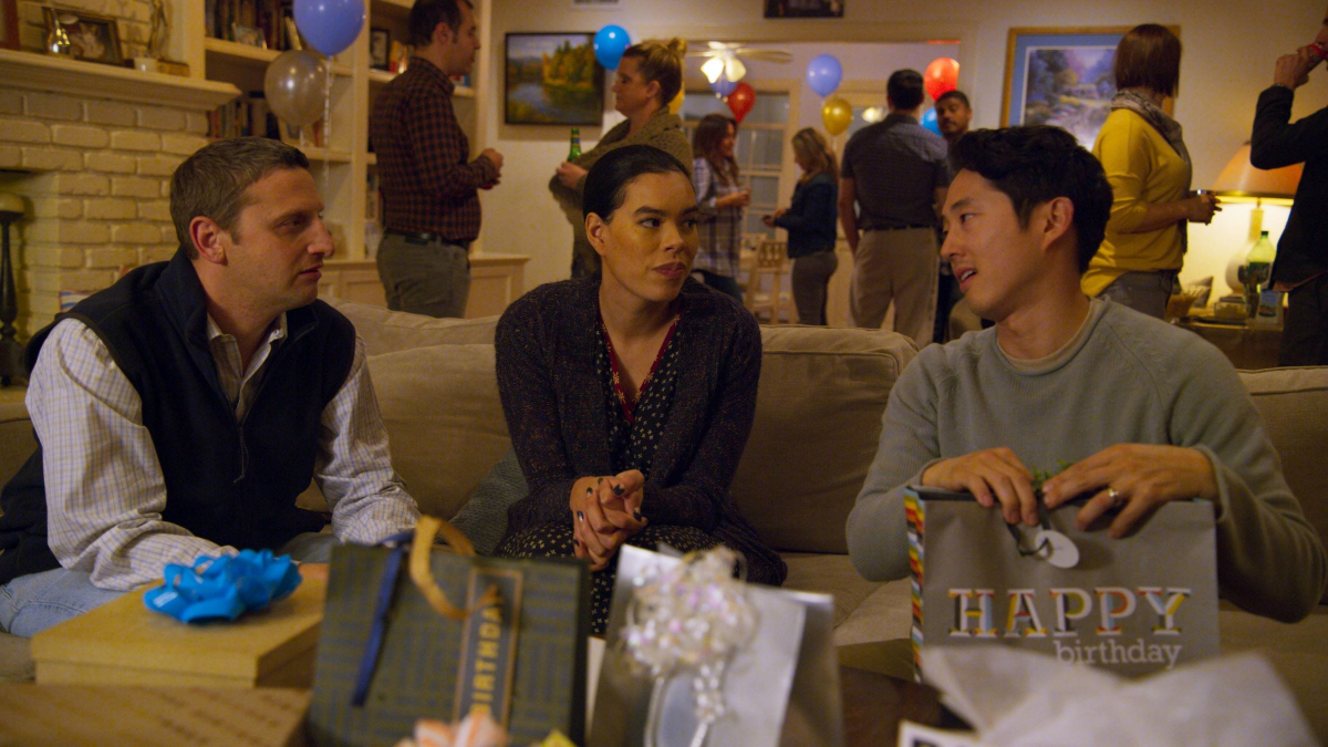 Two friends (Tim Robinson, Brianna Baker) look on as a third (Steven Yeun) opens a birthday gift in 'I Think You Should Leave'