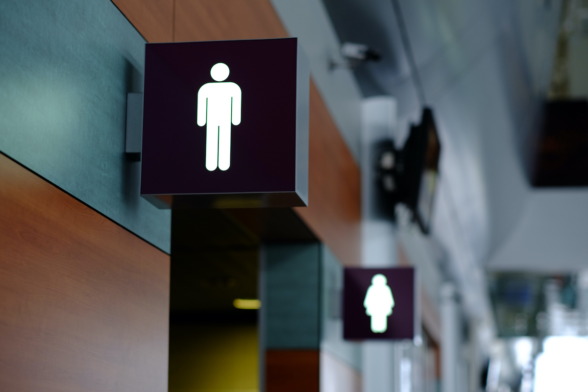 Signs indicating men and women's bathrooms hang above doors.