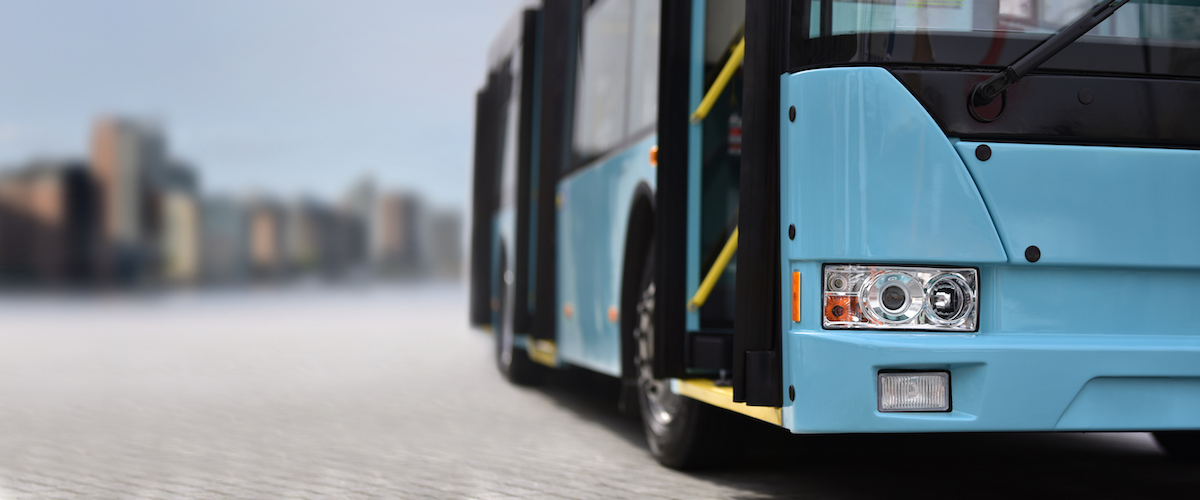 A blue bus drives up to the camera.