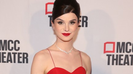 Dylan Mulvaney wears a red gown on a red carpet.