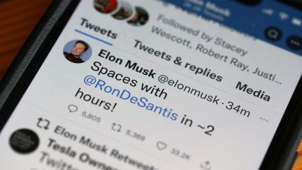 A phone displaying a tweet from Elon Musk announcing a Twitter Spaces event with Ron DeSantis.