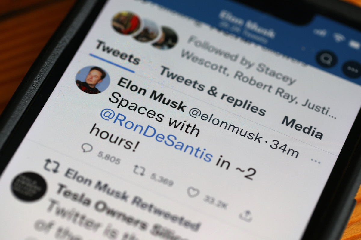 A phone displaying a tweet from Elon Musk announcing a Twitter Spaces event with Ron DeSantis.