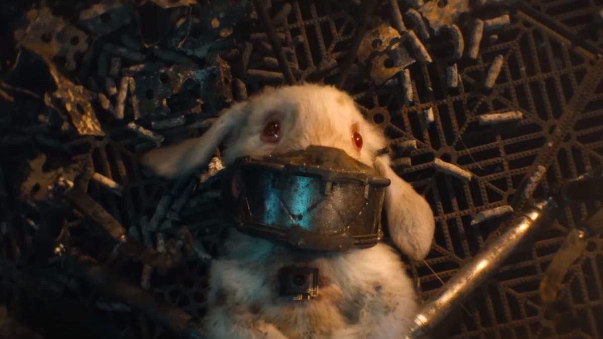 Floor, a white rabbit with a metal muzzle over her face, lies on the floor of her cage in Guardians of the Galaxy Vol. 3.