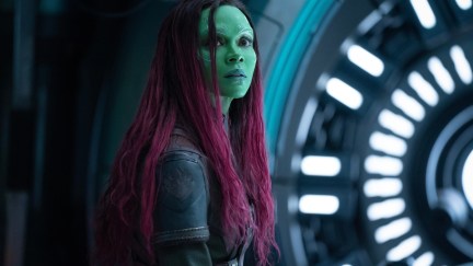 Gamora stands in front of a circular gate in a spaceship.