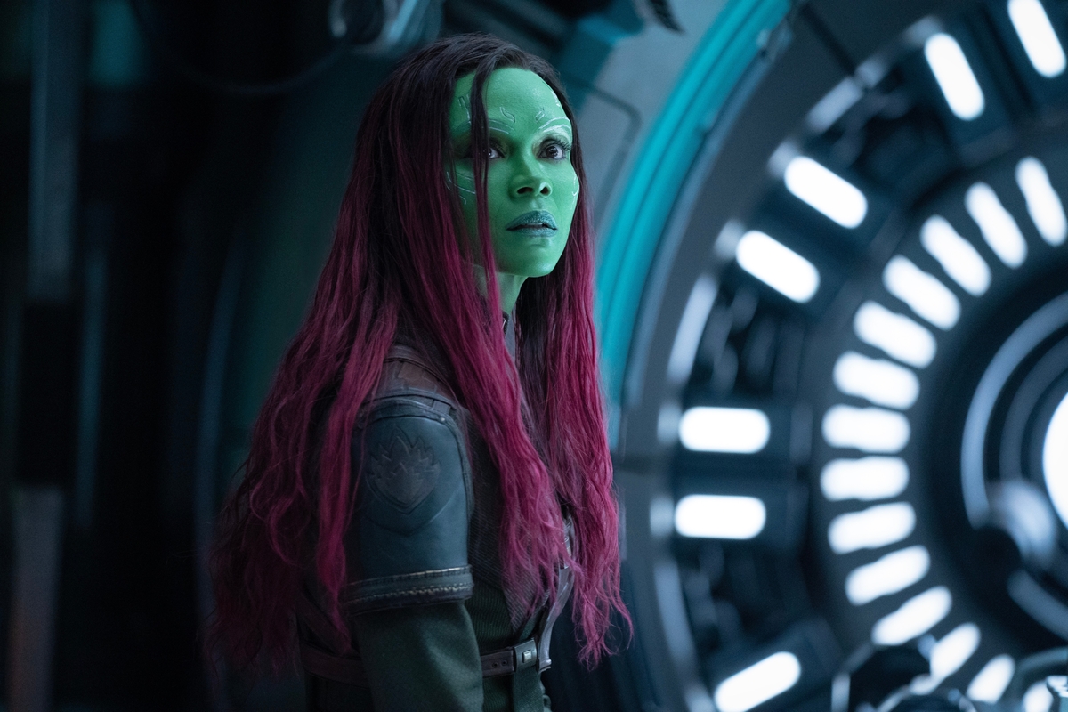Gamora stands in front of a circular gate in a spaceship.