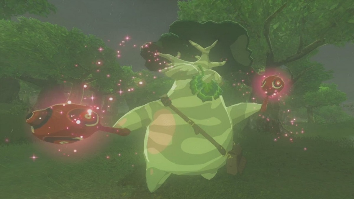 Screenshot of Hestu from 'The Legend of Zelda: Breath of the Wild." Hestu, a Korok, is a chubby being with a dark and light green camouflage-printed body and a tree for a head. He has a large leaf for a face and a brown messenger bag across his body. He is holding out a pair of red maracas in a celebratory fashion as little pink lights swirl around him. He's standing at the edge of a forest.
