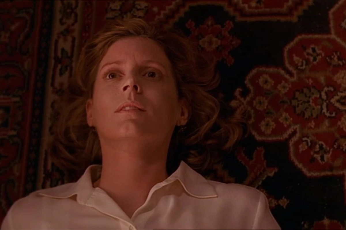 Kristine Sutherland as Joyce Summers in Buffy episode "The Body"; she lies on her back with her eyes open and face blank. She's wearing a white shirt.