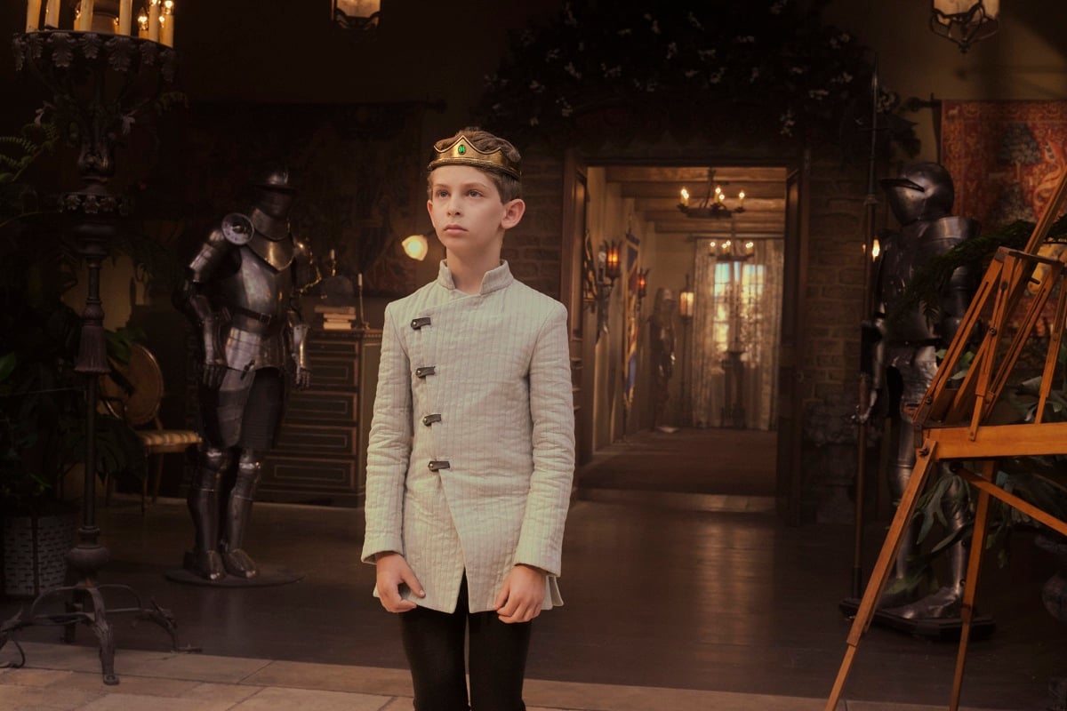 Image of Dylan Von Halle as Young Picard in the STAR TREK: PICARD episode, "Monsters." Young Picard is a white boy wearing a crown and a prince's tunic walking through what looks like it could be a castle or a house.