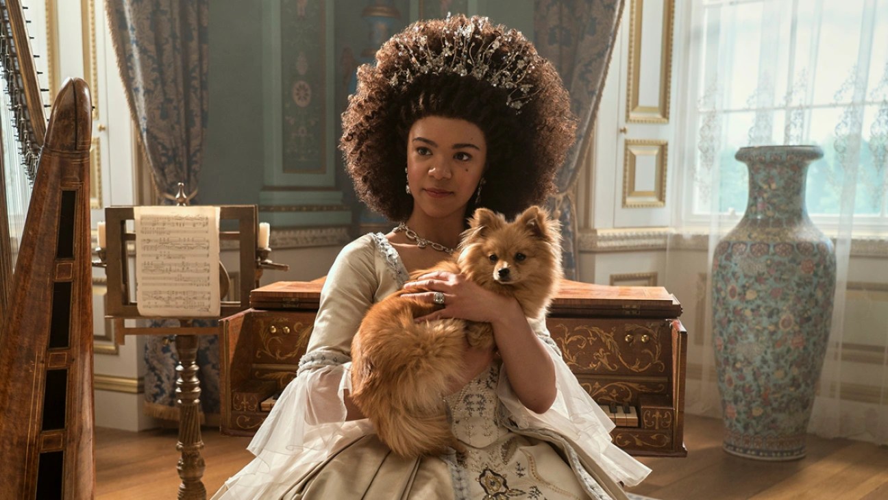 A young Queen Charlotte sits with a Pomeranian on her lap.