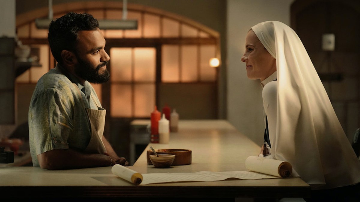 Jay and Simone lean across a counter toward each other, smiling as they talk. From Mrs. Davis.