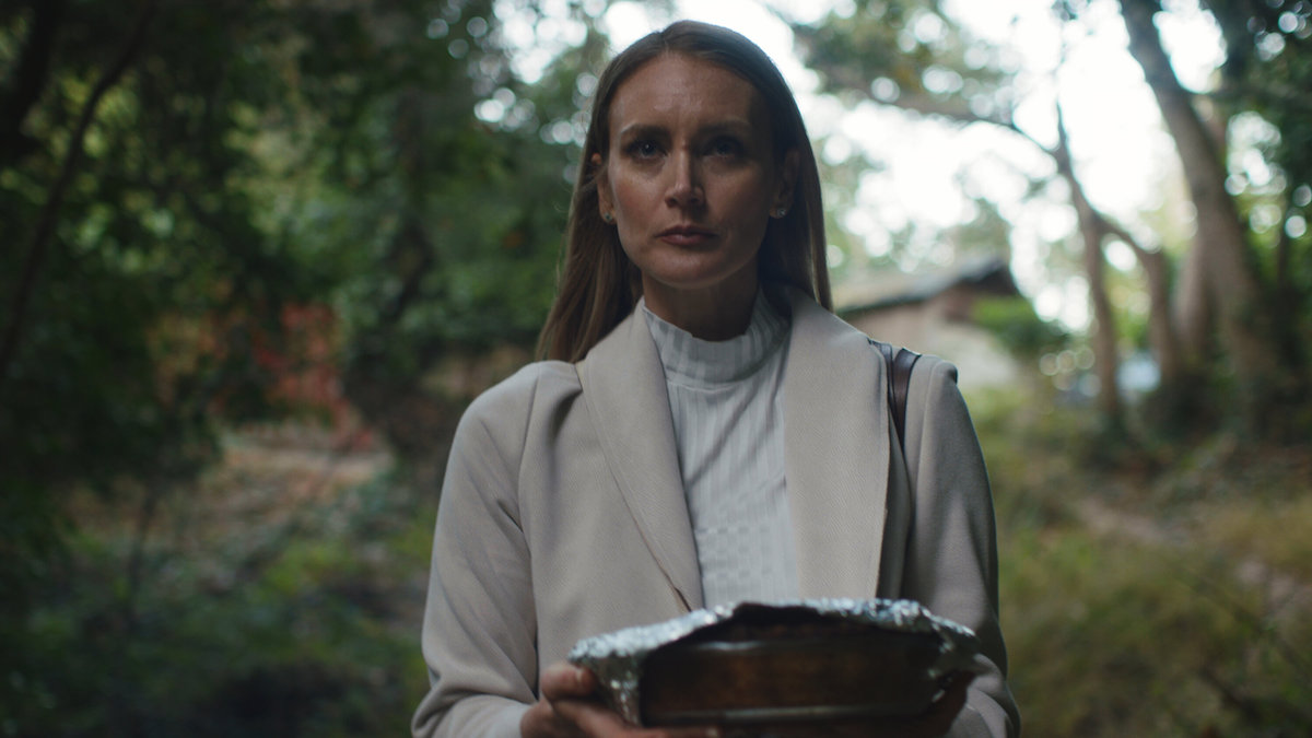 Emily carries a tinfoil-wrapped pie down a wooded path in Soft & Quiet.