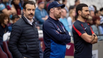 Ted, Beard, and Roy stand on the pitch during a game in Ted Lasso.