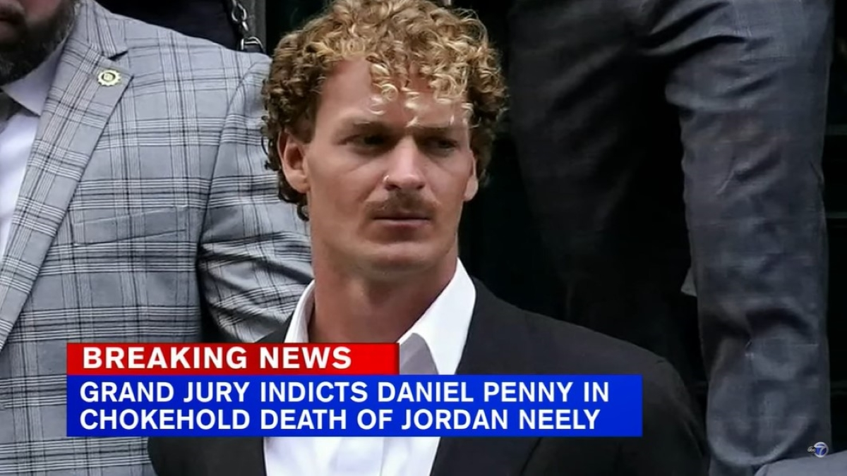 Daniel Penny is transported to his arraignment hearing in May. Text on the screen says, "Breaking News: Grand Jury Indicts Daniel Penny in Chokehold Death of Jordan Neely."