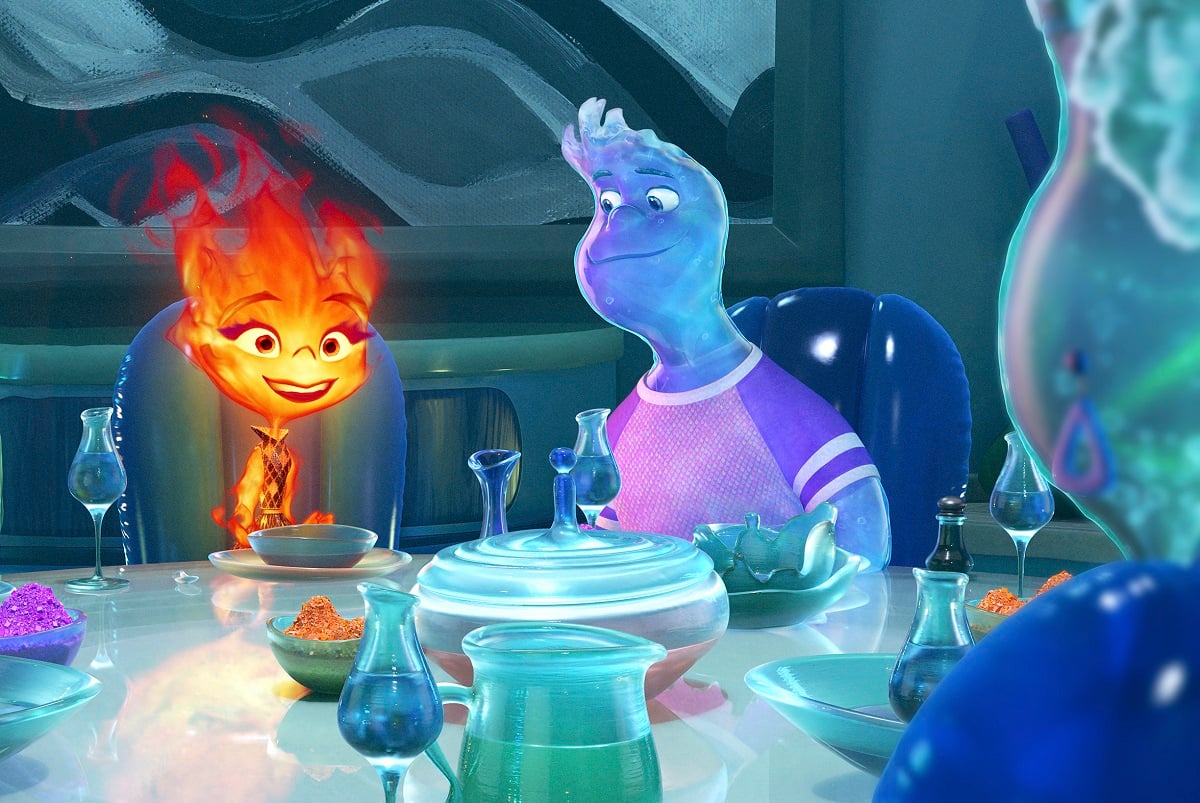 A scene from Pixar's animated film, 'Elemental.' Ember, a female-coded fire element and Wade, a male-coded water element are seated at a dinner table across from Wade's mother, a female-coded water element.