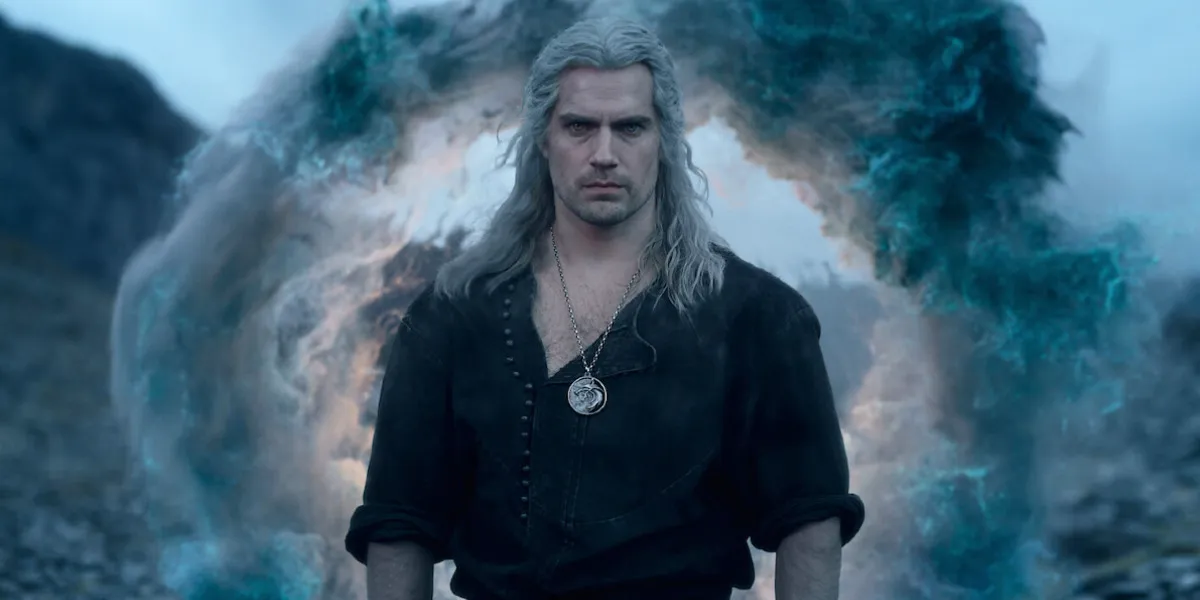 Henry Cavill as Geralt of Rivia in The Witcher season 3, a huge magical portal can be seen behind him.
