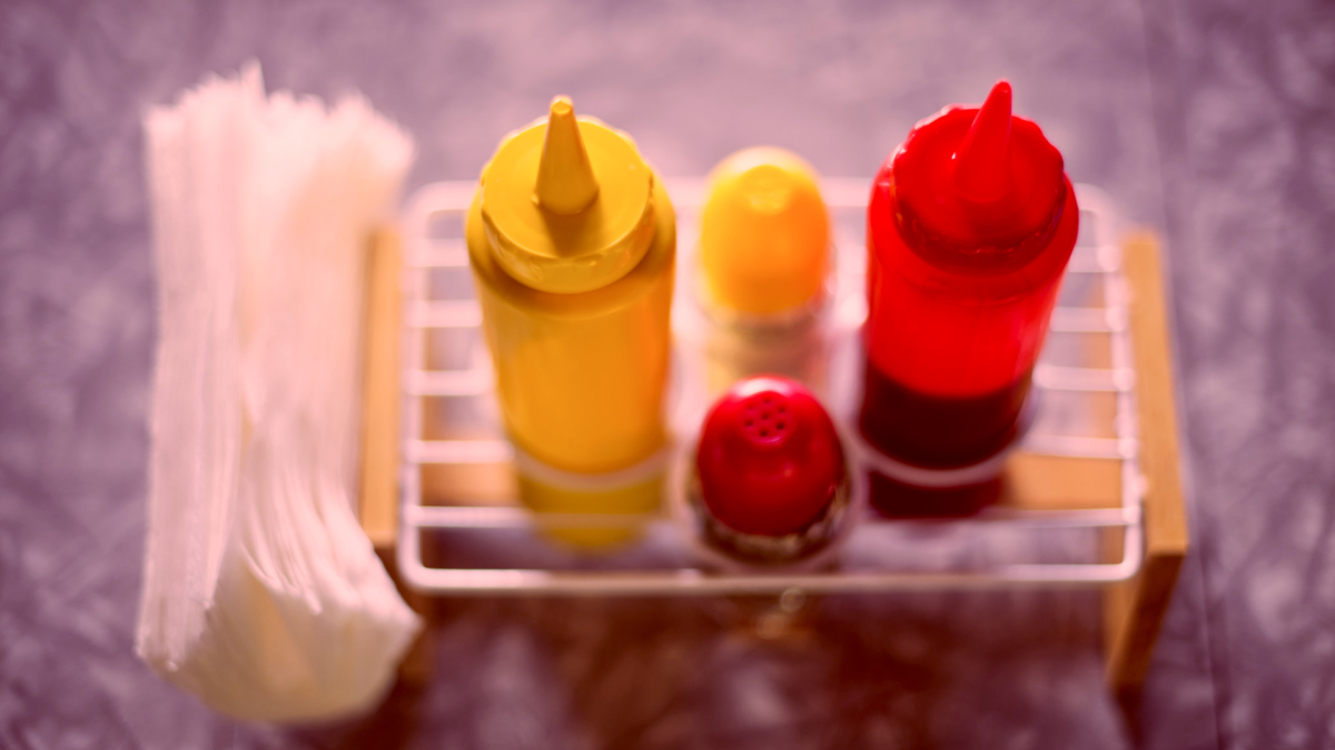 Ketchup, mustard, and napkins tinged in a jarring red tone.