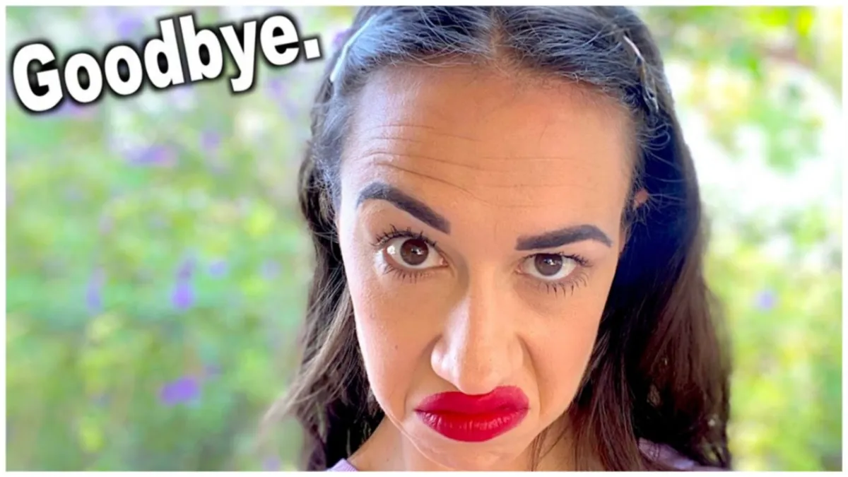Screenshot from Miranda Sings Youtube Channel, "My Final Video"; Colleen Ballinger, a white woman with slick backed hair and badly applied red lipstick, makes a weird face while standing outside near trees. A caption in the top left corner reads "Goodbye".