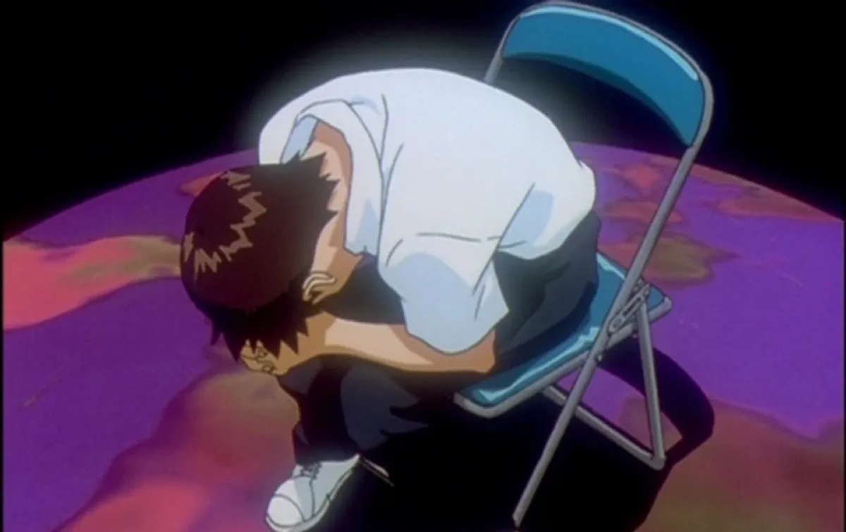 Shinji doubled over in a chair in End of Evangelion.