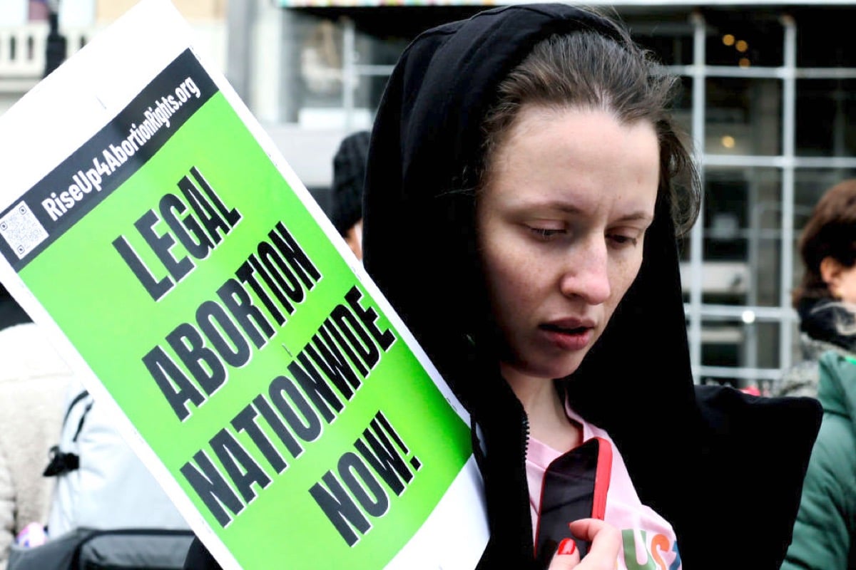 An abortion rights protestor with a sign demanding nationwide abortion legalization.