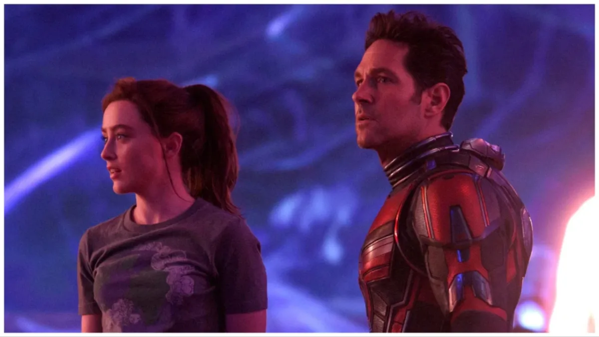 In a still from 'Ant-Man and the Wasp: Quantumania,' Cassie (Kathryn Newton) stands next to her father, Scott Lang. Scott is wearing his Ant-Man suit without the helmet, so his face his visible.