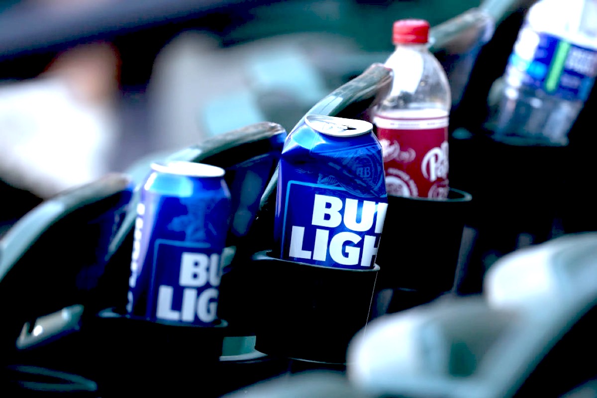 Bud light cans in cupholders. One is crushed.