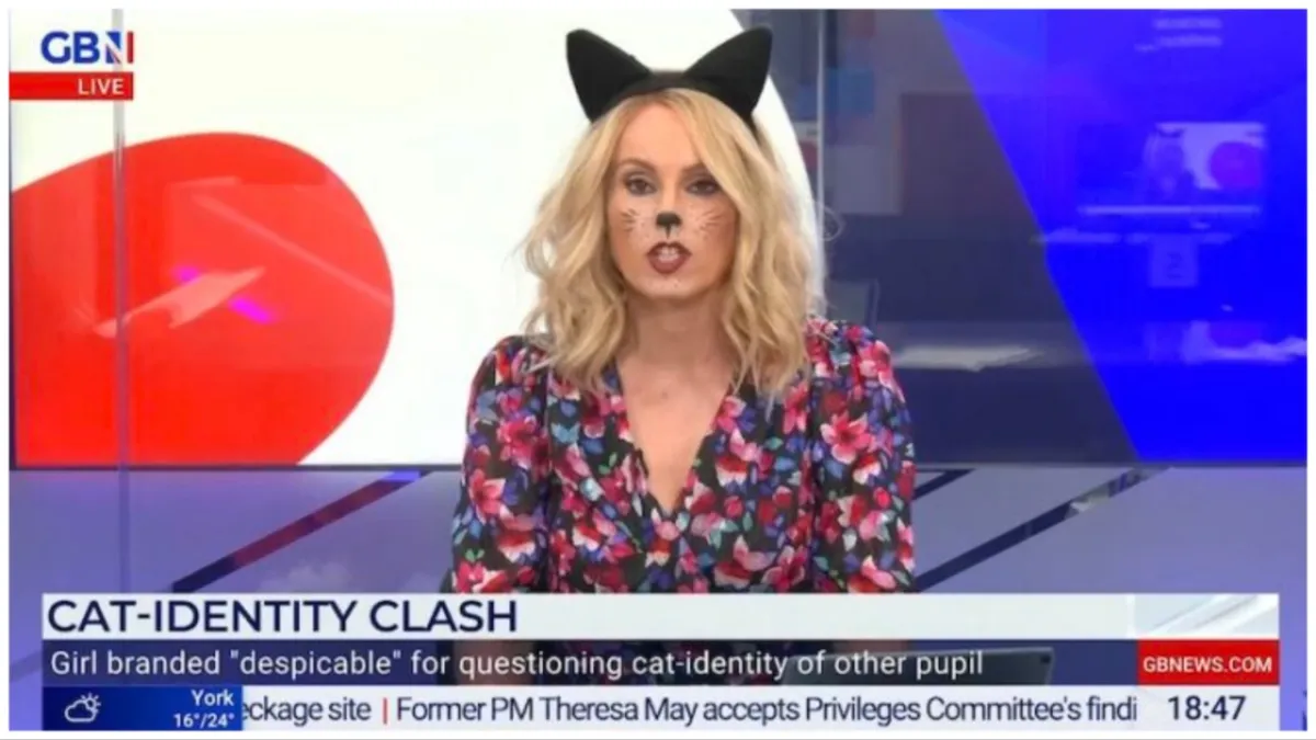 Still of Michelle Dewberry on GB News; a white, blonde woman with cat ears and cat face paint sits in front of an abstract background.