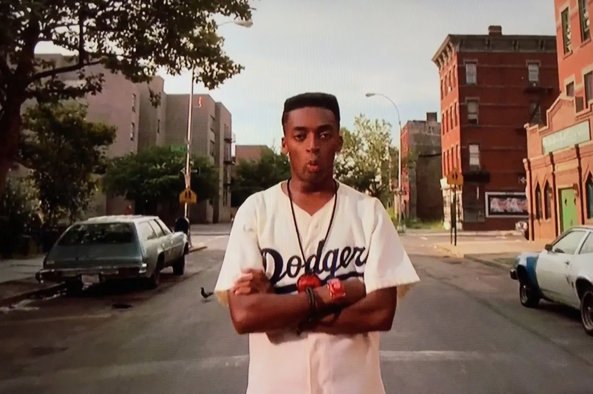 A young man in a Dodgers jersey stands in the street with arms folded in "Do The Right Thing" 