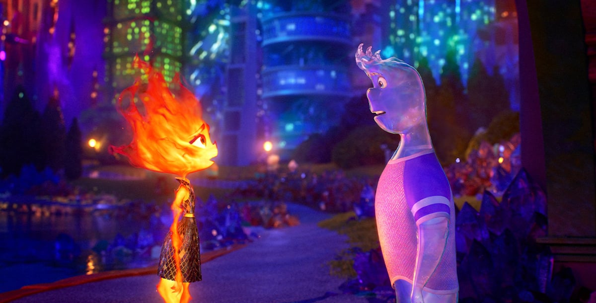 Ember and Wade stare at each other with an evening city skyline behind them in 'Elemental.'