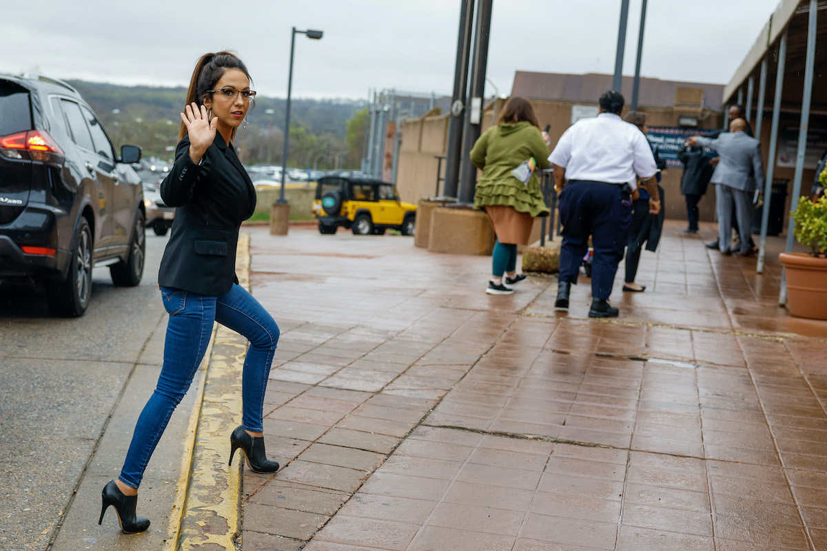 Lauren Boebert hods her hand up to the photographer as she walks outside.