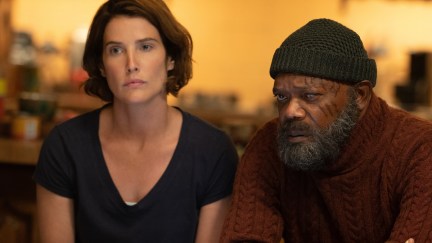 Maria Hill and Nick Fury look at something off camera, sitting in a dimly lit room.