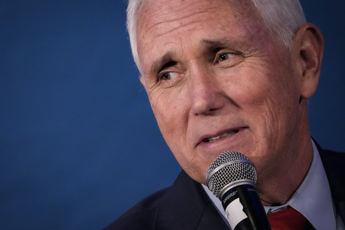A close-up of Mike Pence's face, speaking into a microphone and looking uneasy.