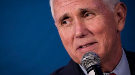 A close-up of Mike Pence's face, speaking into a microphone and looking uneasy.
