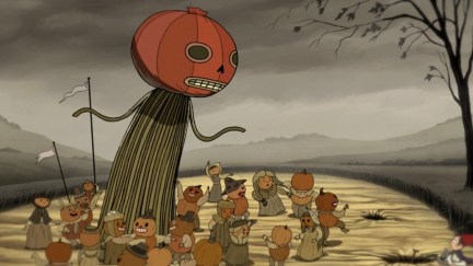 A group of villagers, each with a pumpkin for a head, dance around a giant pumpkin-headed figure. The sky is grey, the grass is brown, and a nearby tree is skeletal.