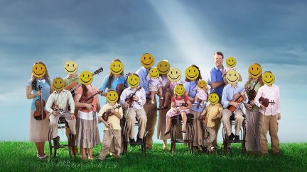 The Duggar family, consisting of about 20 people, stands on the grass with a ray of light touching their heads. They all have a yellow happy face over their real faces.