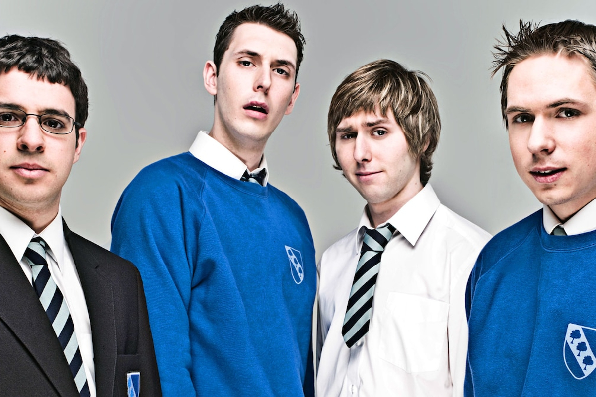 The Inbetweeners promotional picture; Simon Bird, Joe Thomas, James Buckley and Blake Harrison, a group of white teenage boys, stand together wearing a blue, white and black school uniform.