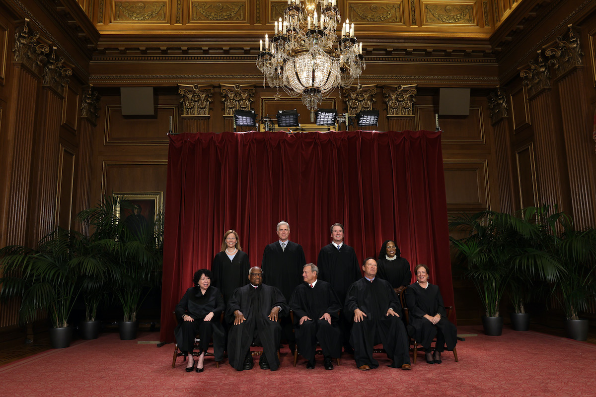 A zoomed-out photo of the Justices of the Supreme Court posing together for a portrait.