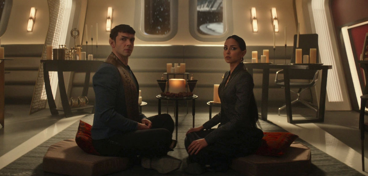 Spock and T'Pring sit on a rug in Spock's quarters, surrounded by candles.