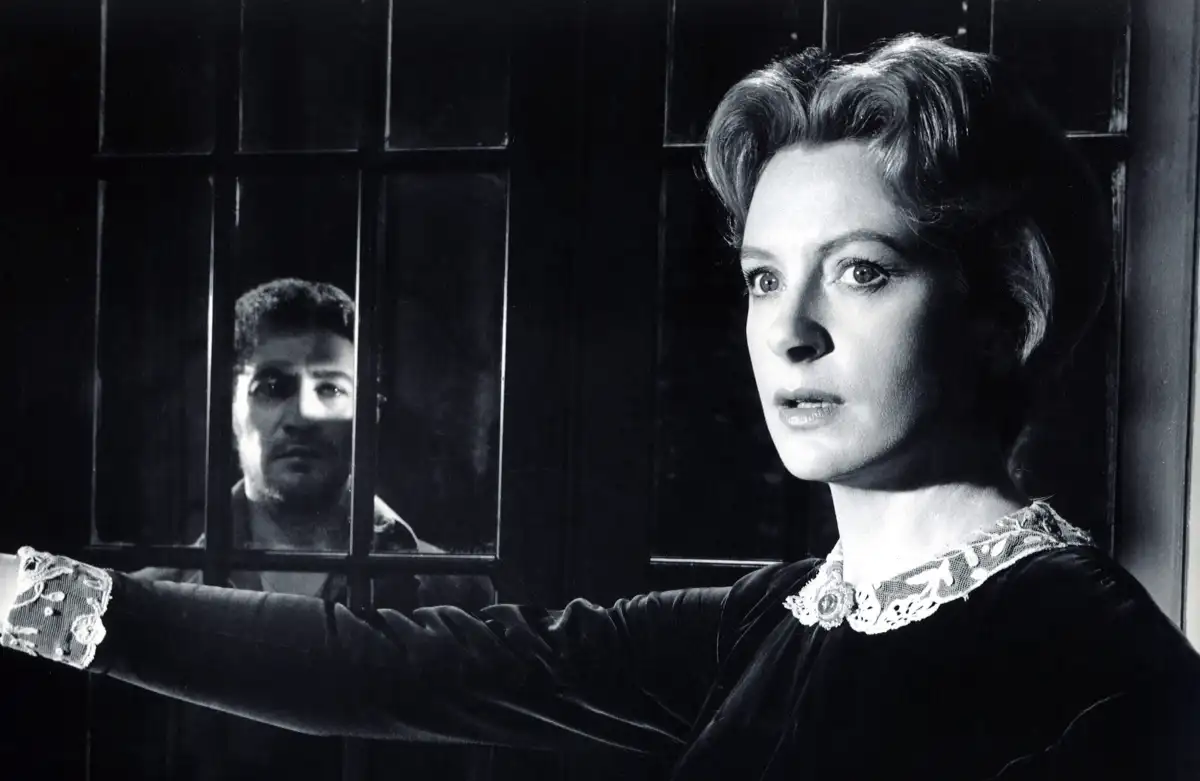 The governess in "The Innocents" stares nervously into the camera.
