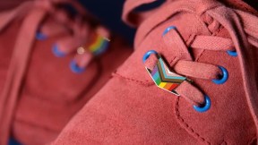 The Pin Prick's Progress Pride Shoe Locks; pink suede shoes with a progress pride enamel shoelaces lock on the laces.