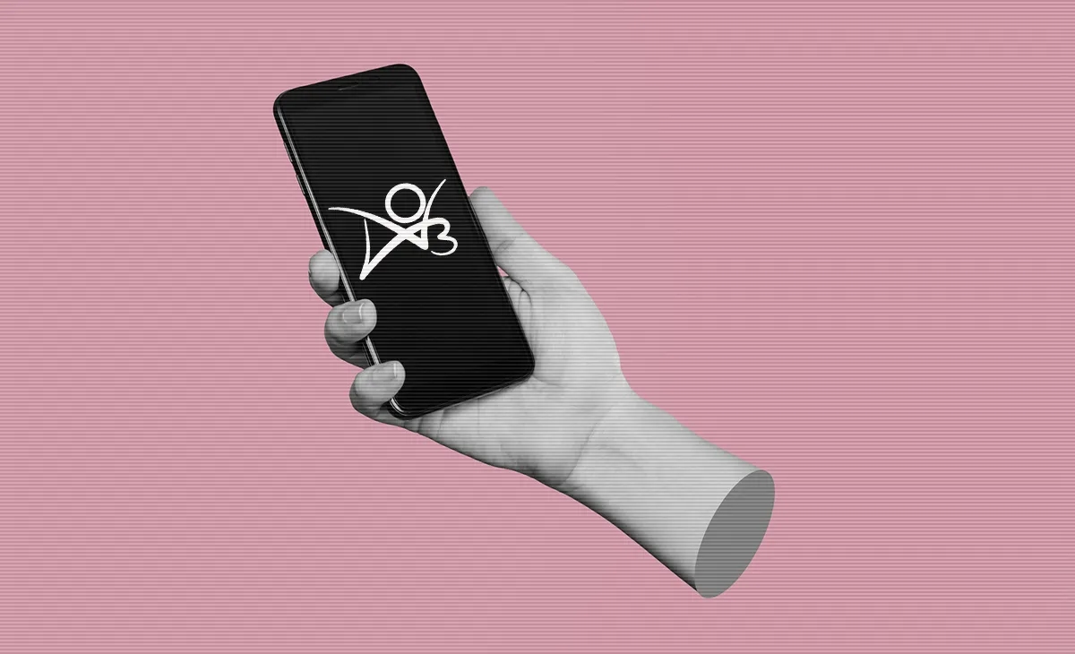 Mobile phone with black screen in female hand isolated on a pink color background. A white logo for Archive of Our Own is visible on the phone screen.