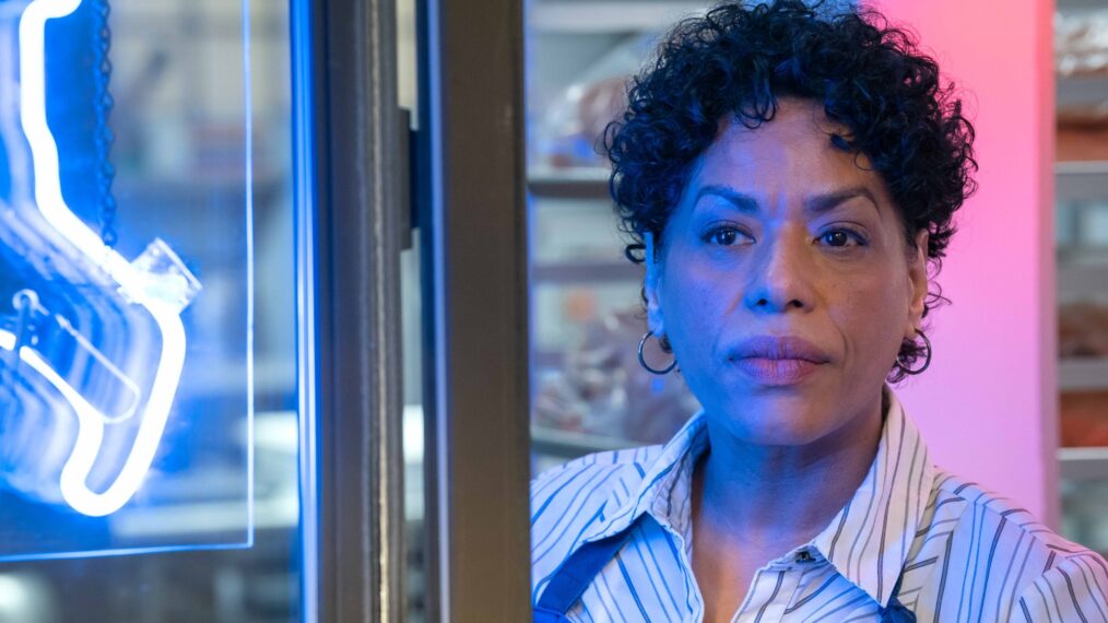 Chef Tina in 'The Bear': Latinx woman with short hair staring into the camera surrounded by pink and blue light.